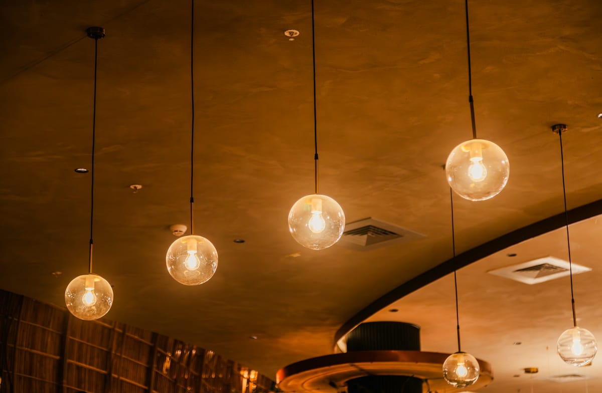 Premium interior furniture and warm pendant lighting arranged for trade interior supply